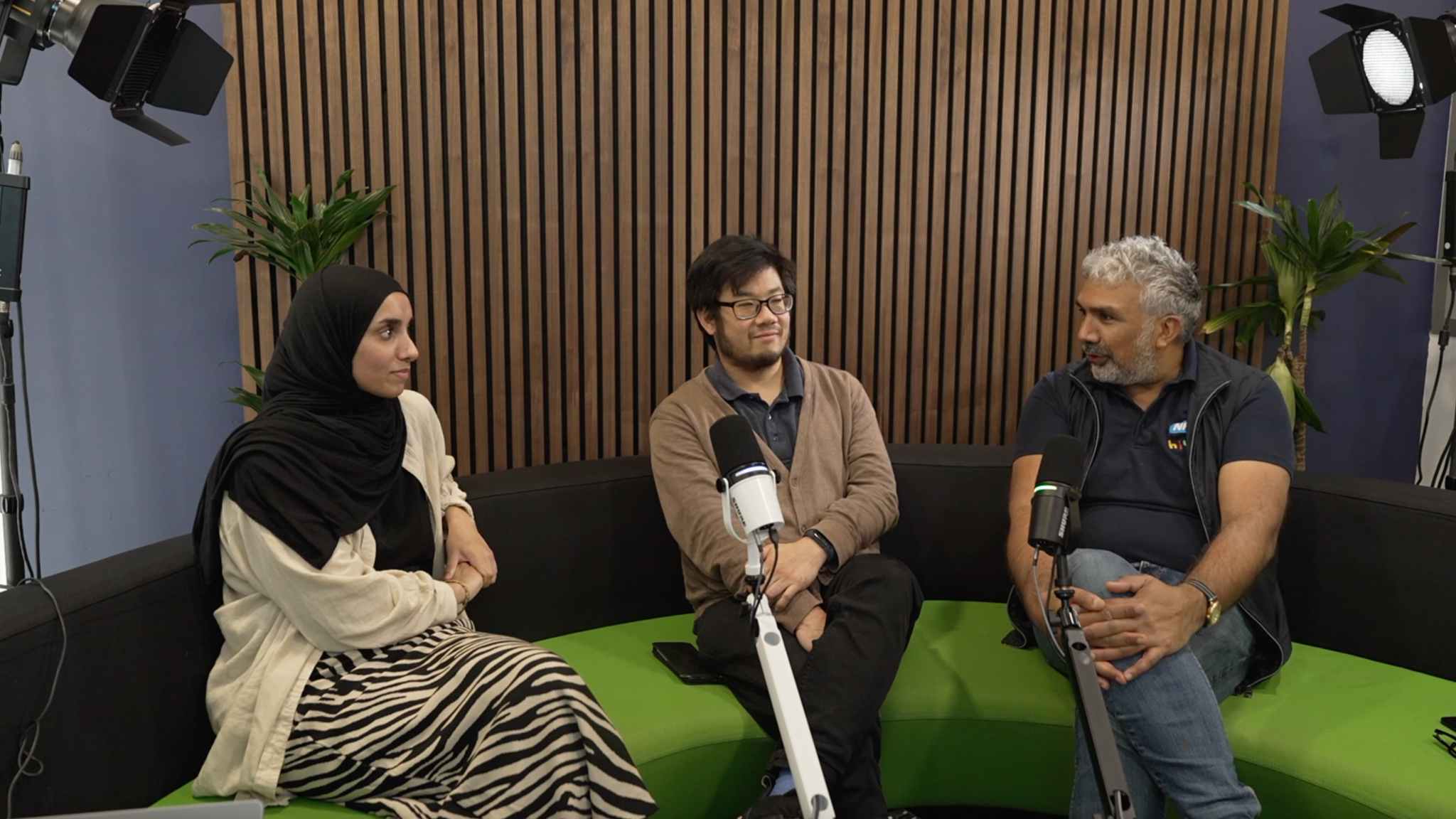 3 people 2 men and a woman on a sofa. They are recording a podcast