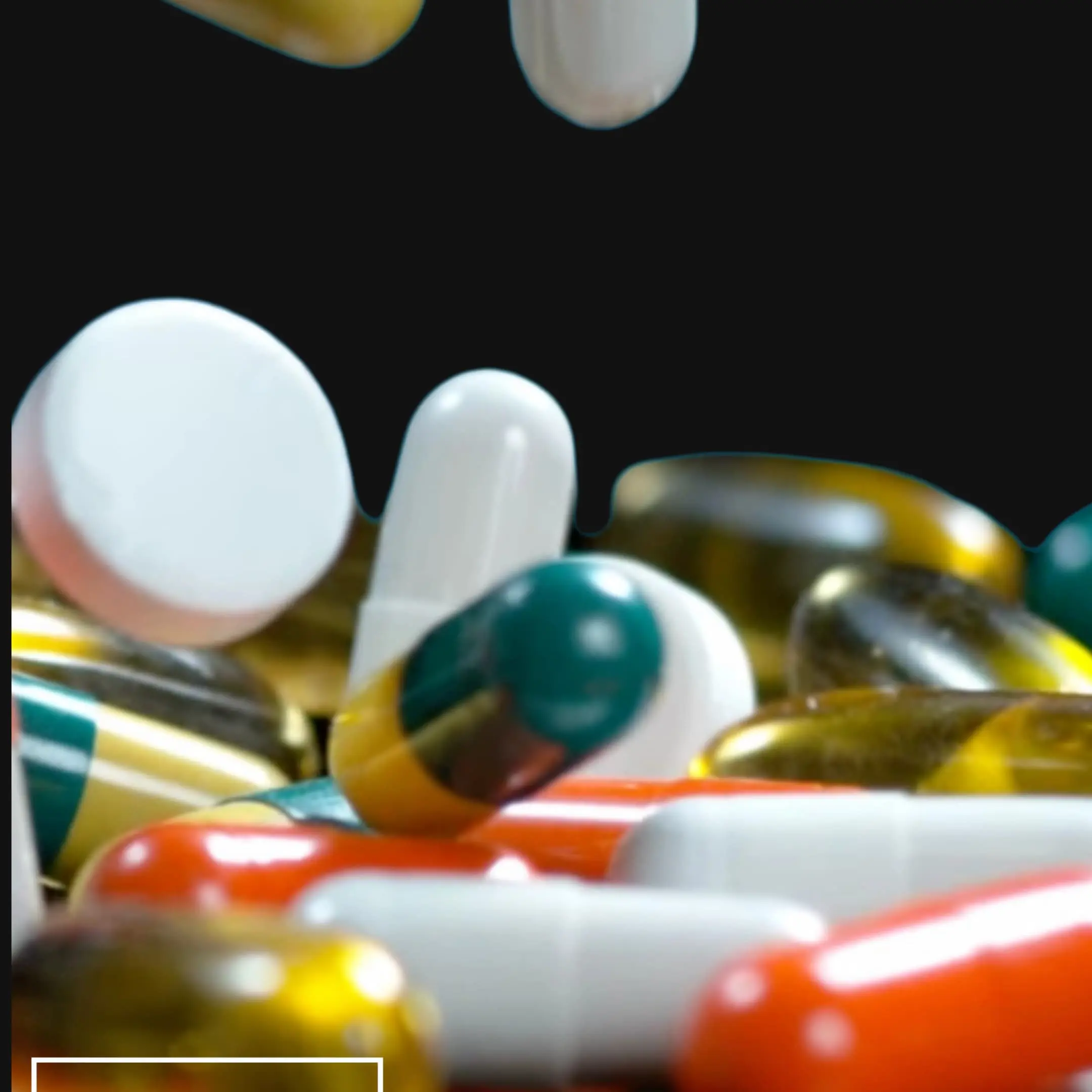 Pills of different colours bouncing on a table. Black background